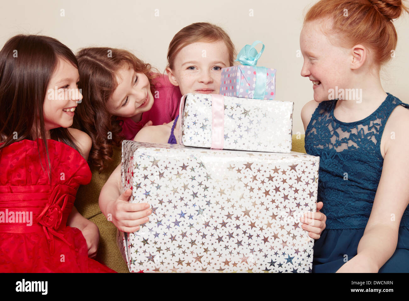 Girl holding birthday present with friends Stock Photo - Alamy