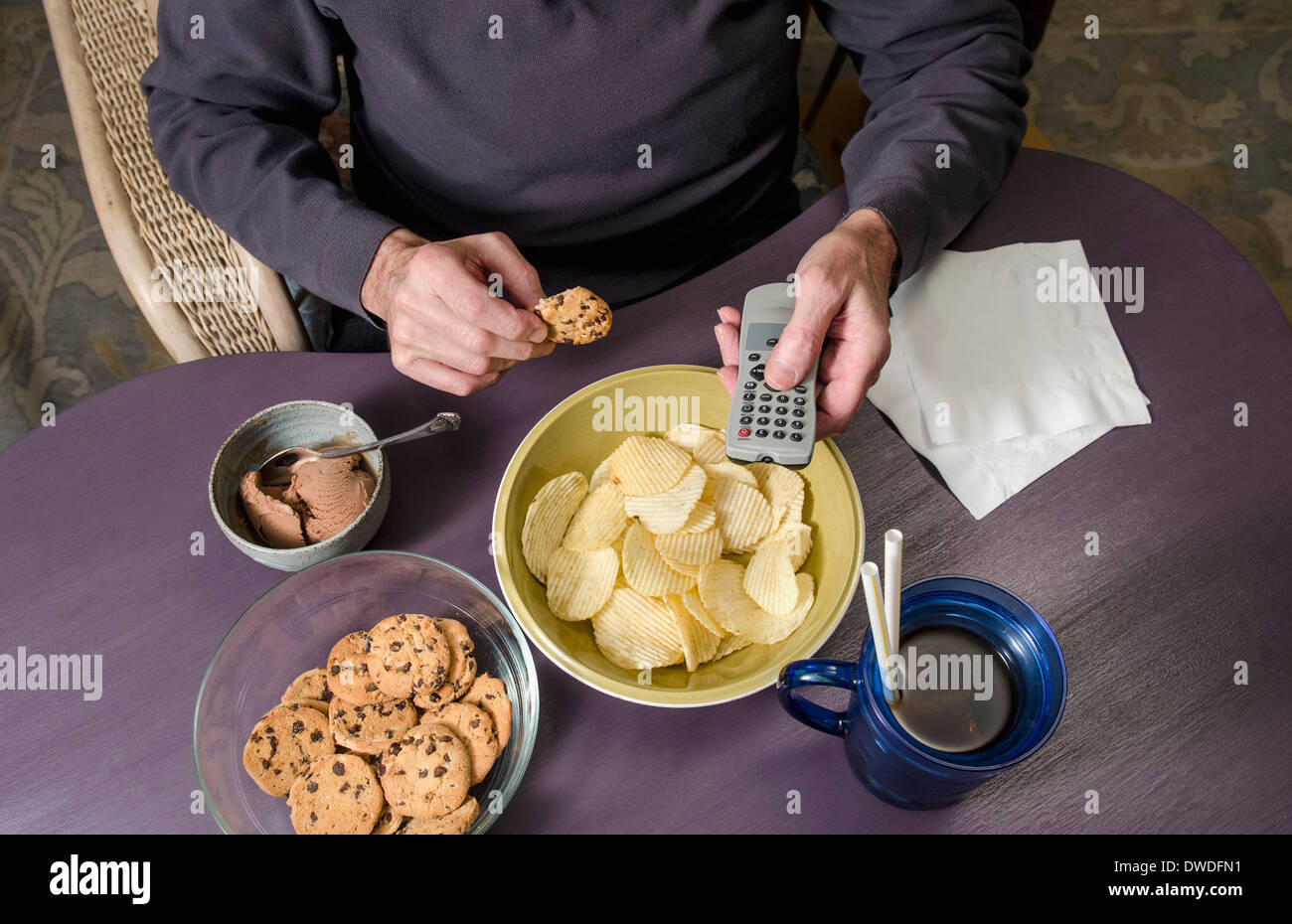 man eating junk food watching television Stock Photo