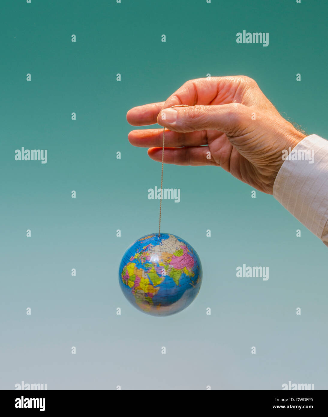 hand with dangling globe Africa, Europe, Asia, Russia prominent Stock Photo