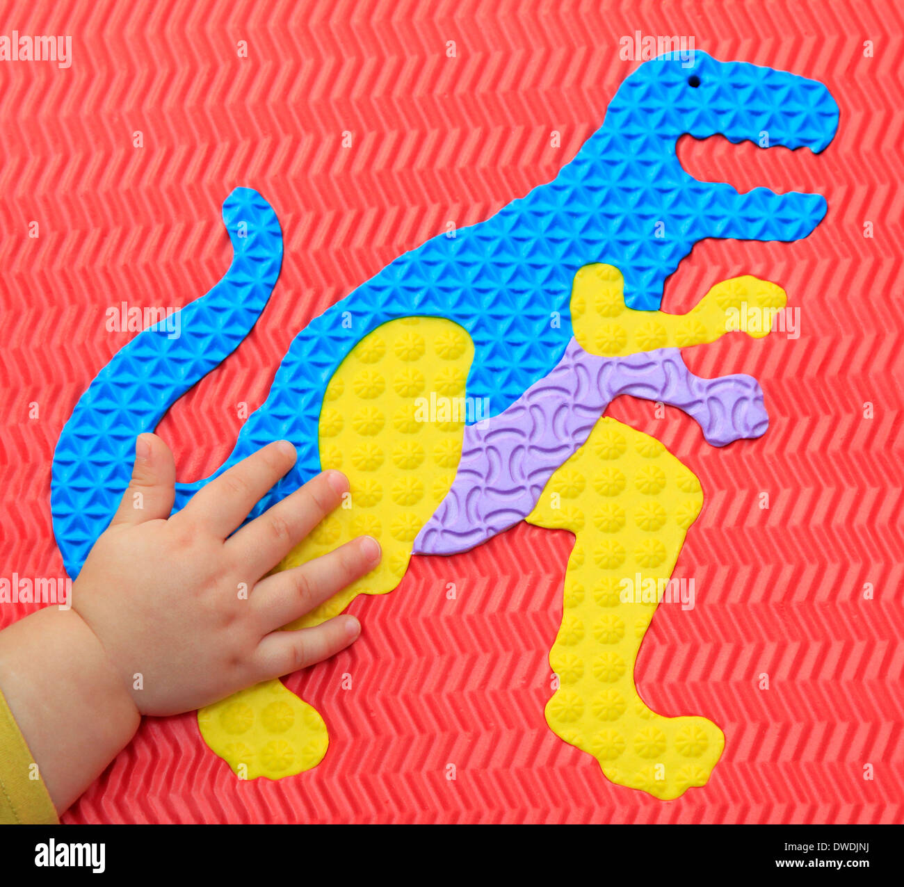 Small hand on dinosaur shape Stock Photo