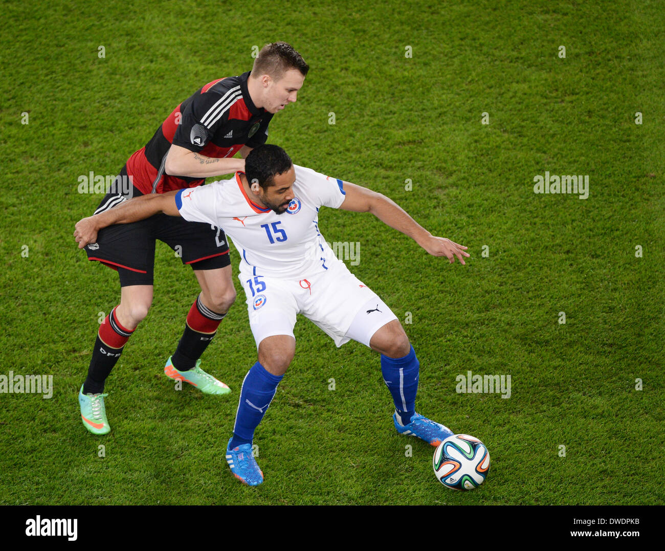 Stuttgart, Germany. 05th Mar, 2014. Germany's Kevin Grosskreutz (L) vies for the ball with Chile's Jean Beausejour speaks with referee Mark Clattenburg during the international friendly match between Germany and Chile at Mercedes-Benz-Arena in Stuttgart, Germany, 05 March 2014. Photo: Patrick Seeger/dpa/Alamy Live News Stock Photo