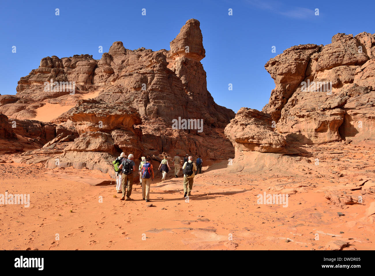 Algeria, Sahara, Tassili N'Ajjer National Park, group of people hiking in the rocks at Tin Merzouga Stock Photo