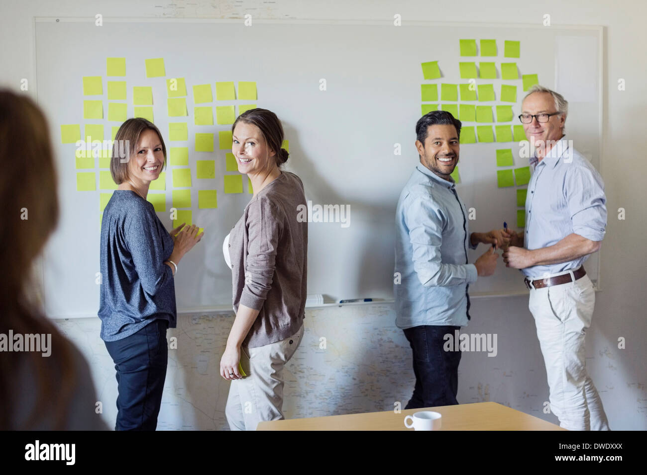 Happy business people standing by whiteboard at office Stock Photo