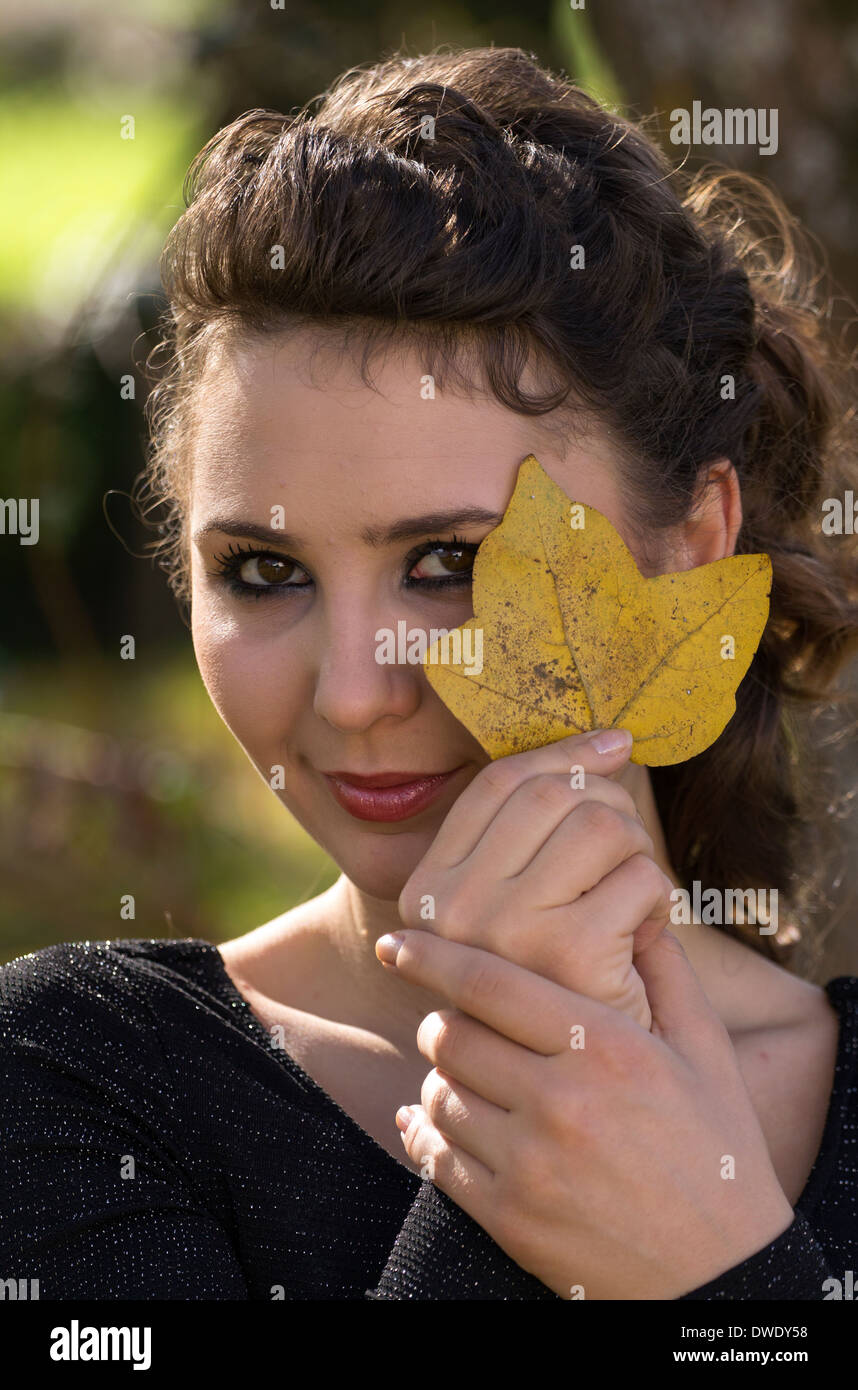 Woman holding an autumn leaf by her face Stock Photo - Alamy