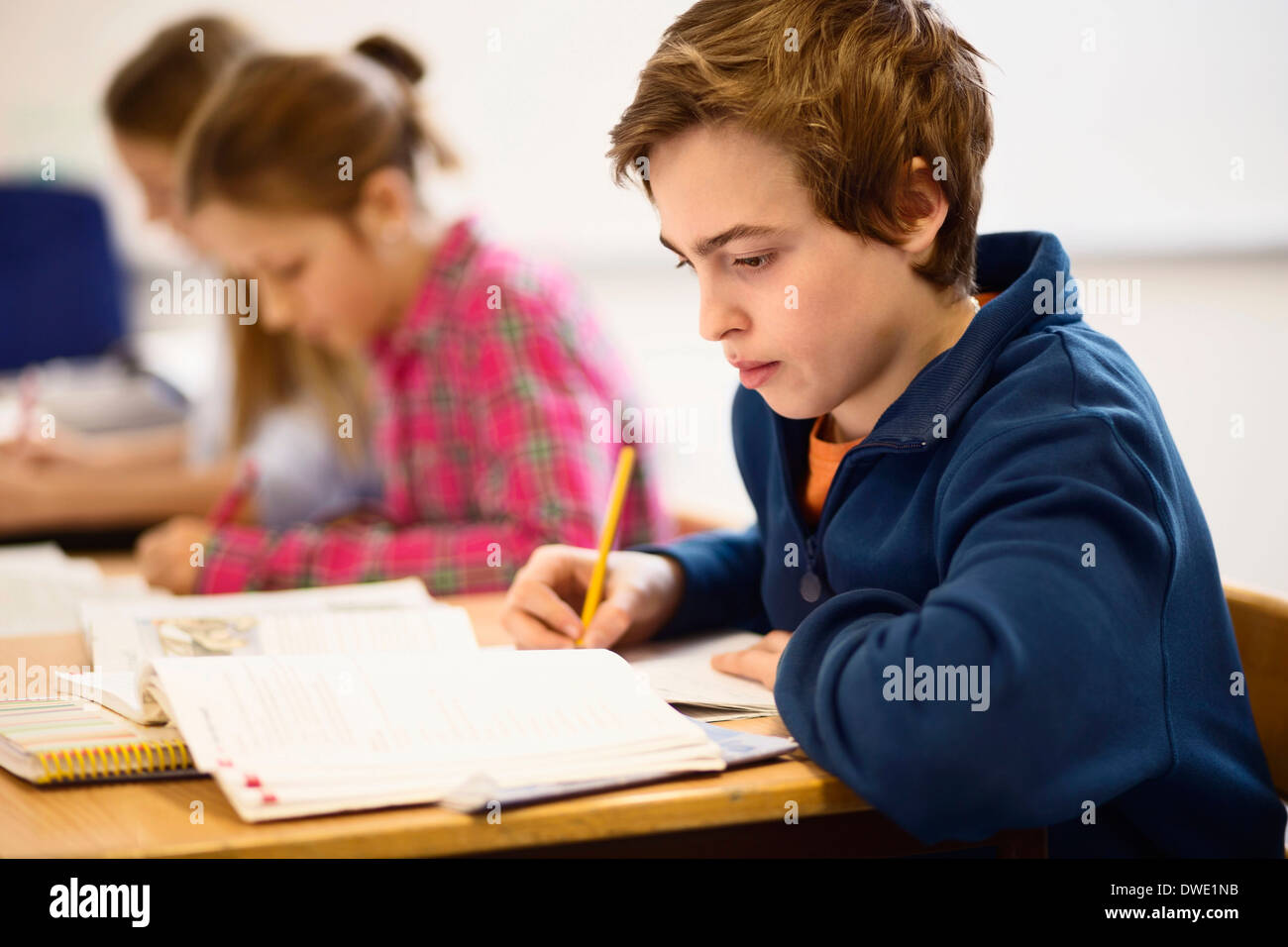 High school students studying at desk in classroom Stock Photo