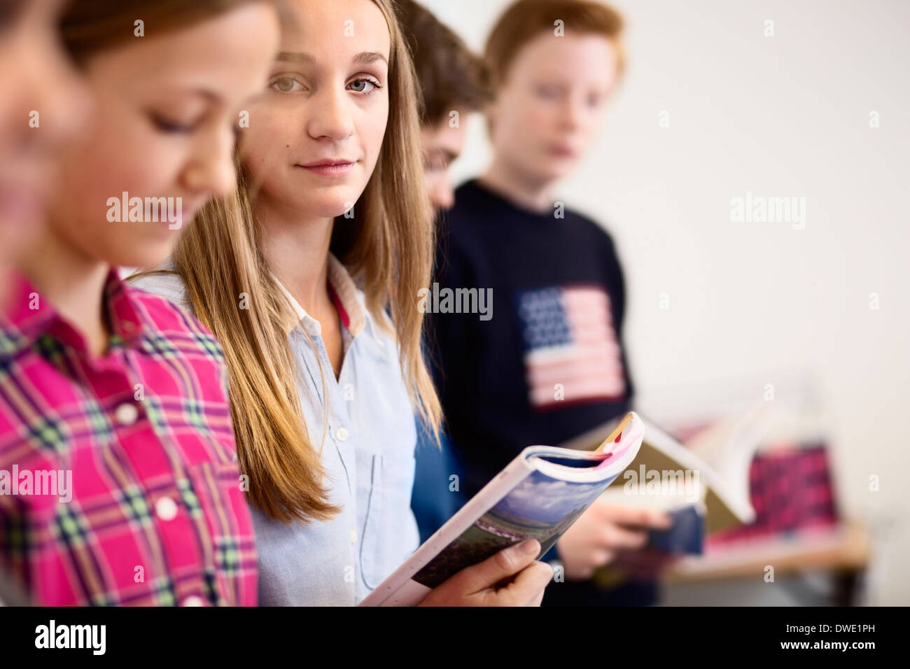 Portrait of high school girl with friends studying in classroom Stock ...