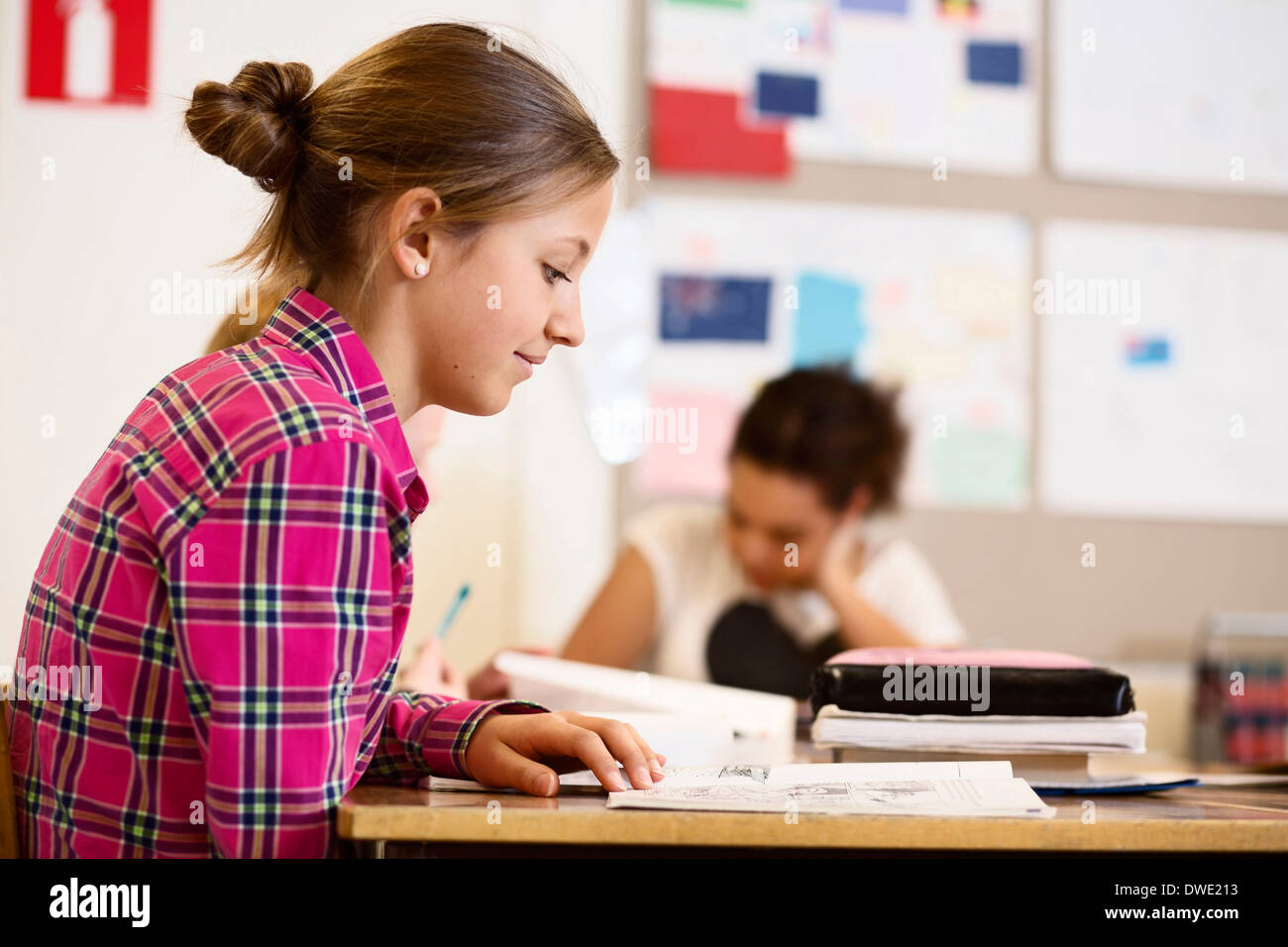 Schoolgirl studying at desk in classroom Stock Photo
