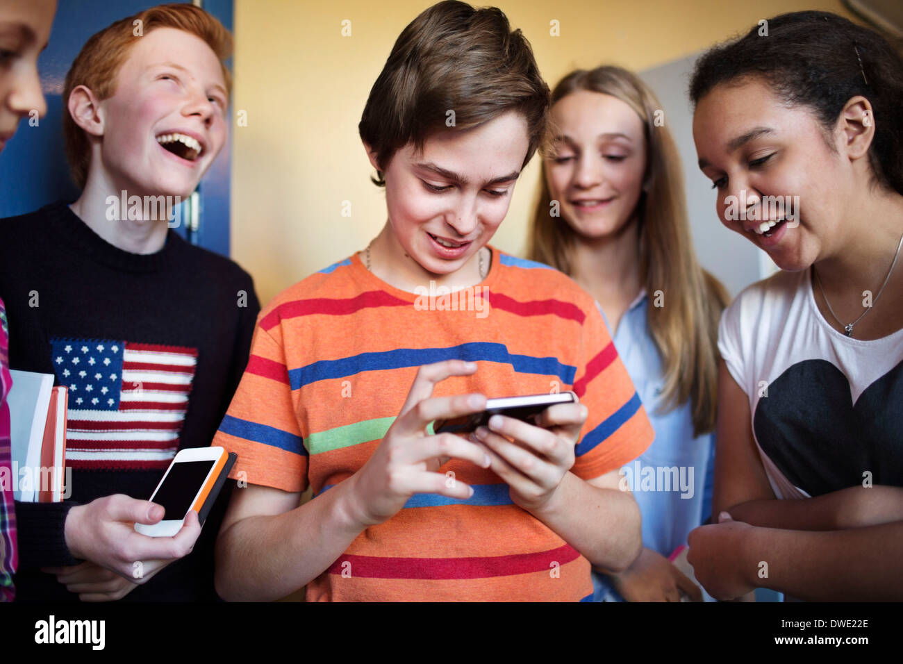 Happy students using cell phones in high school Stock Photo Alamy