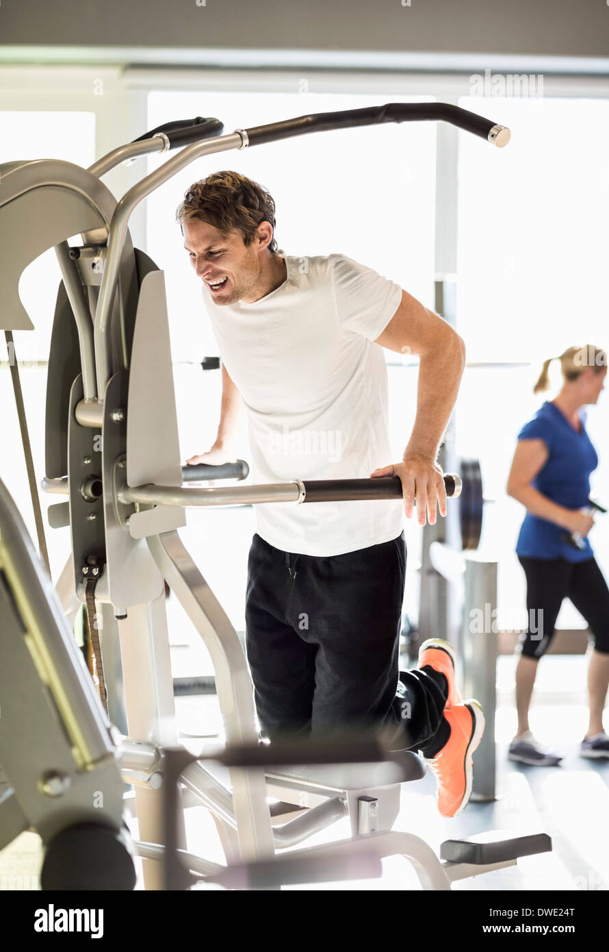 Man exercising on pullup assist machine at gym Stock Photo Alamy