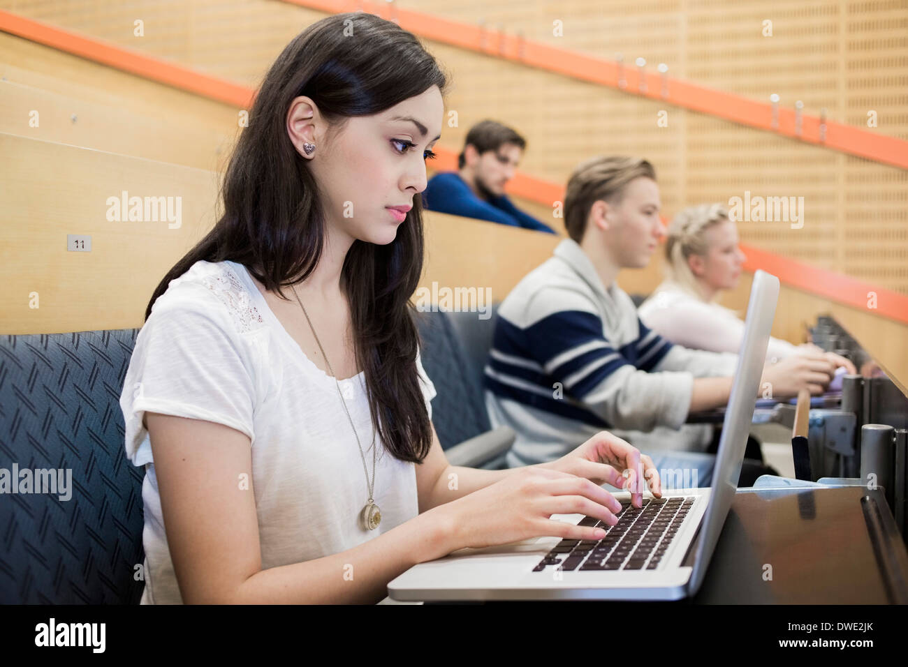 Female university student using laptop in classroom Stock Photo