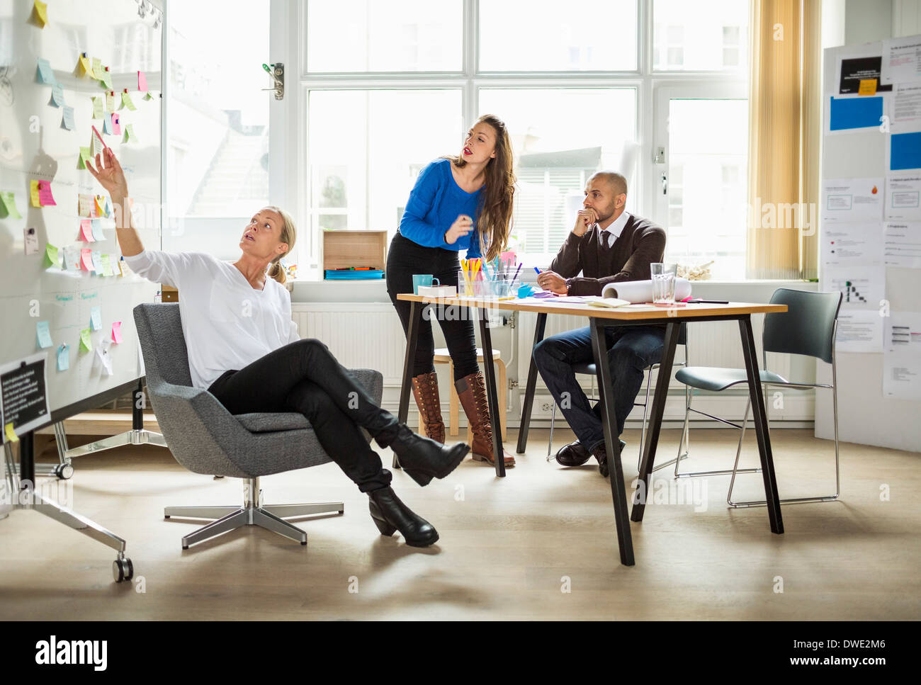 Business people discussing over adhesive note in creative office Stock Photo