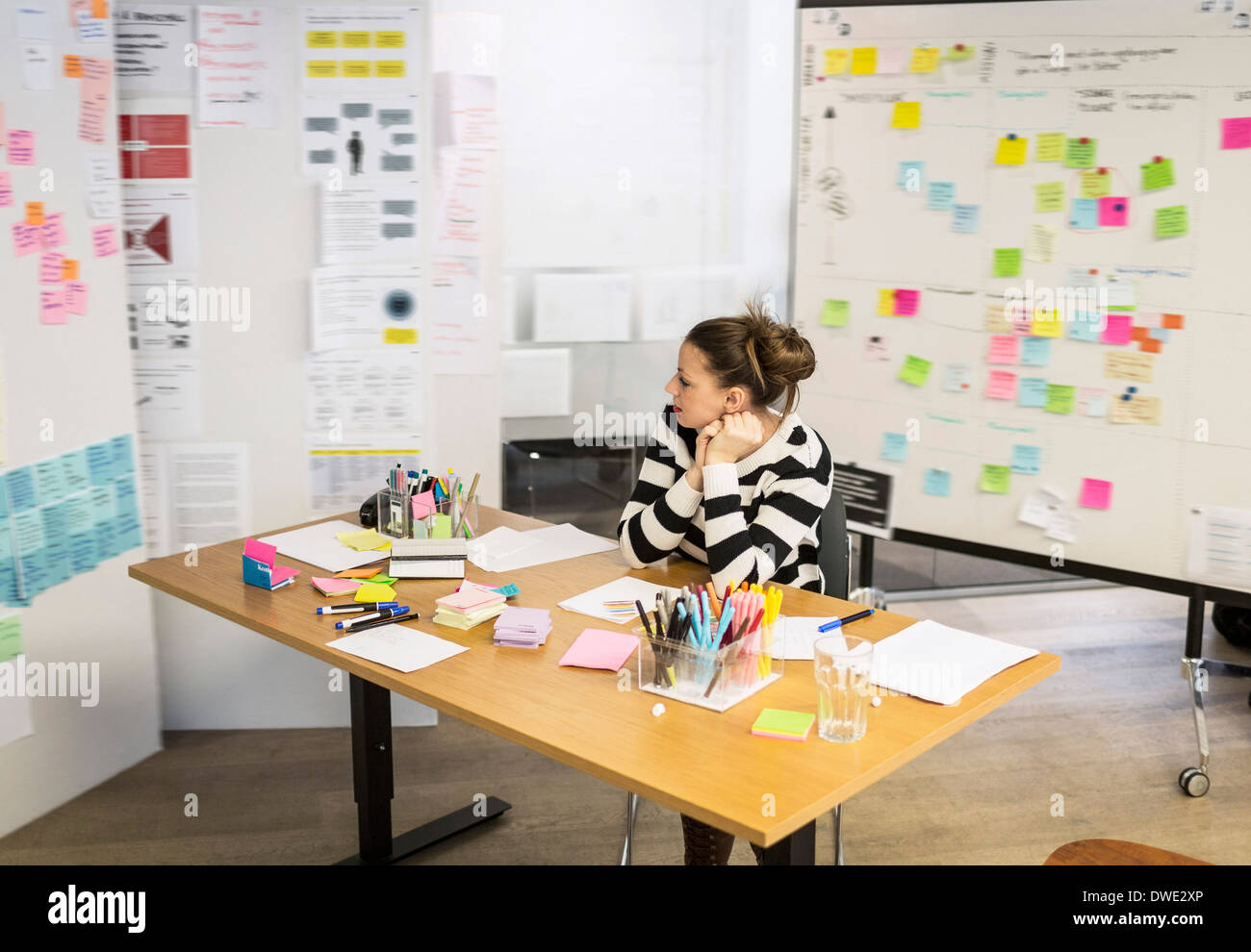 Businesswoman looking at reminders in creative office Stock Photo