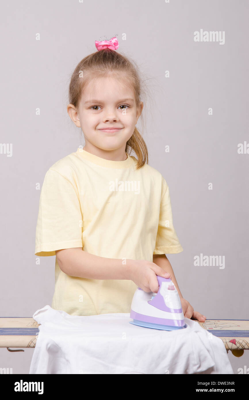 A Five Year Old Girl Playing In A Housewife And Stroking Things Iron a-five-year-old-girl-playing-in-a-housewife-and-stroking-things-iron