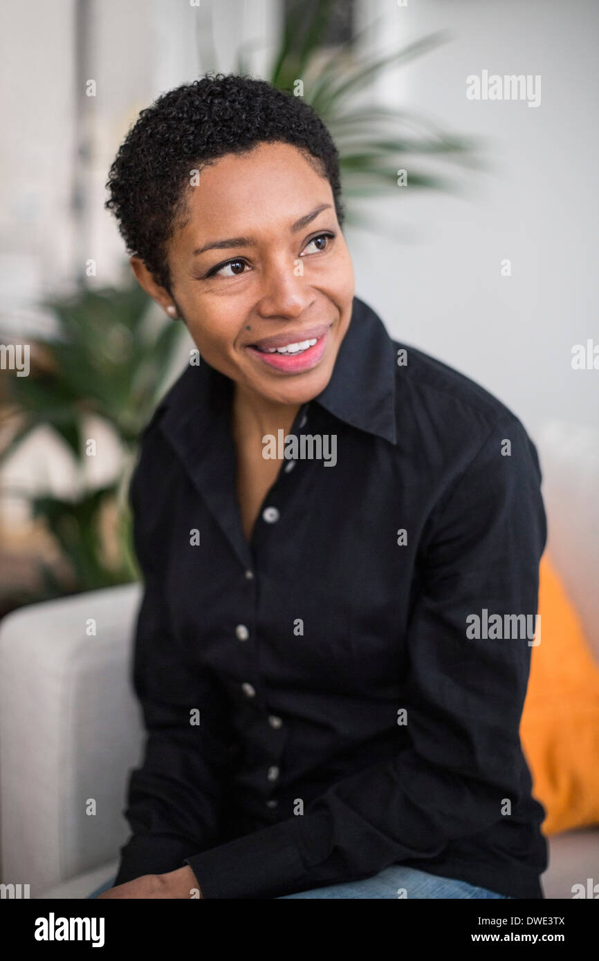 Thoughtful mature woman sitting in living room Stock Photo - Alamy