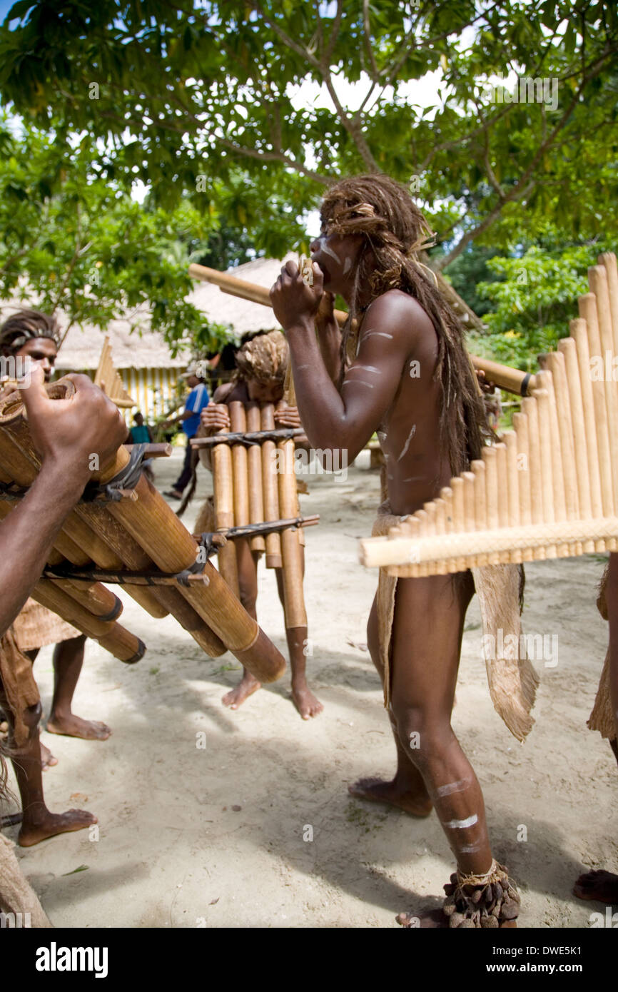 Young men from the Roderick Bay's pipe band perform on handmade bamboo mouth harps, Nggela, Solomon Islands, South Pacific Stock Photo
