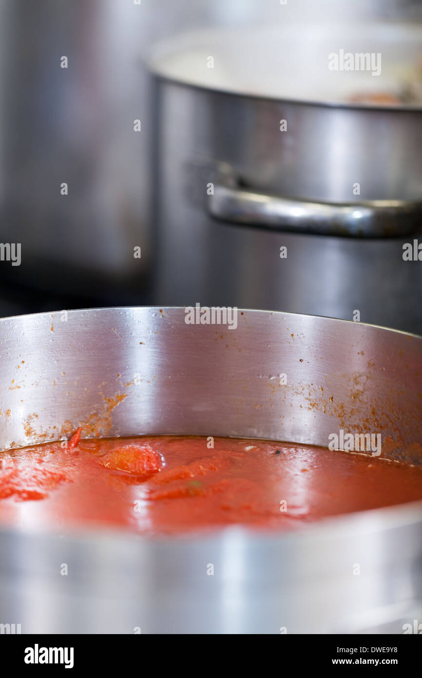 Cooking in a commercial kitchen with large stainless steel pots filled