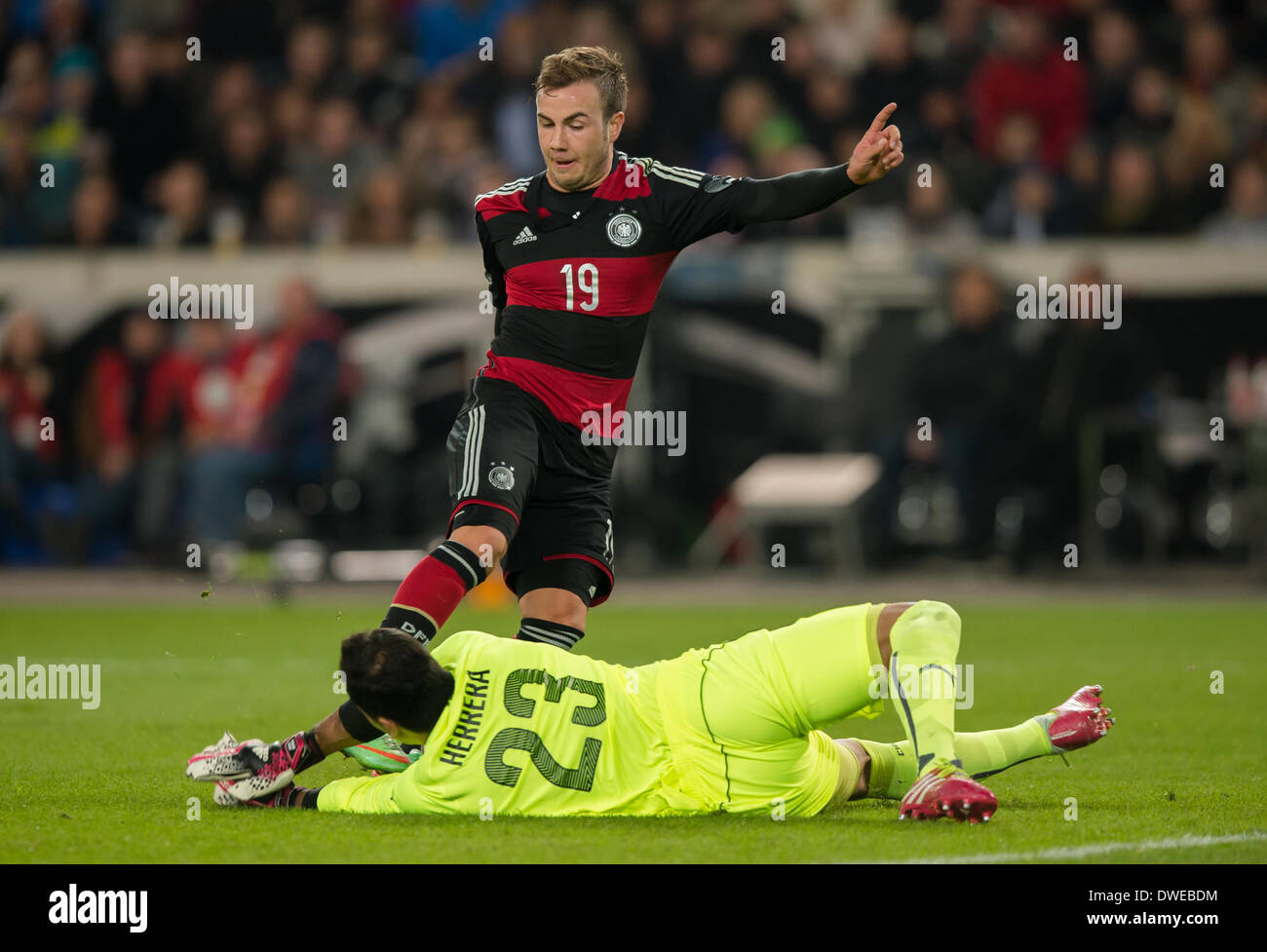 Stuttgart, Germany. 05th Mar, 2014. Germany's Mario Goetze (BACK) against Chile's goal keeper Johnny Herrera during the international match between Germany and Chile at Mercedes-Benz Arena in Stuttgart, Germany, 05 March 2014. Photo: Thomas Eisenhuth/dpa - ATTENTION! NO WIRE SERVICE -/dpa/Alamy Live News Stock Photo