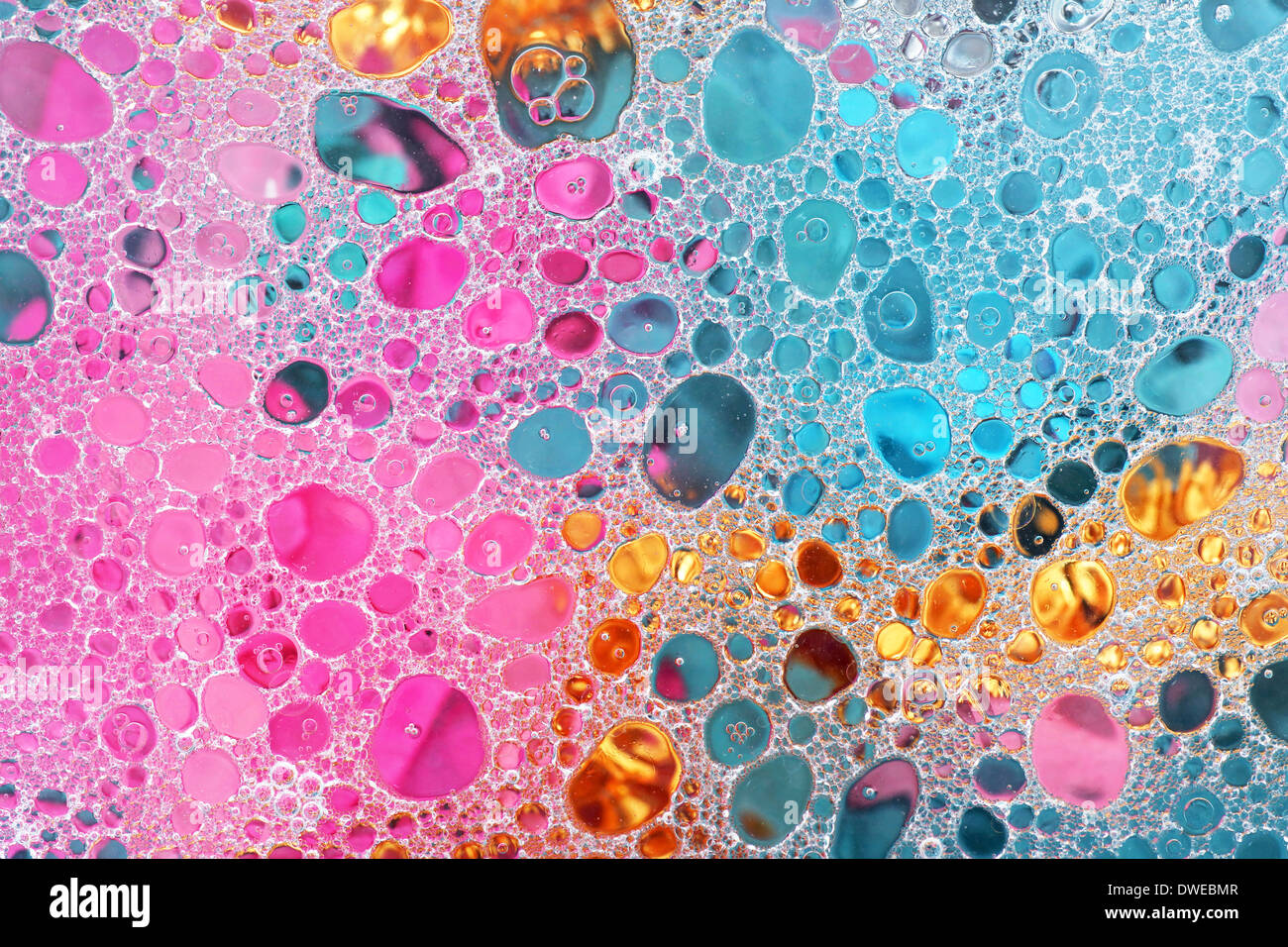 Abstract oil and water bubbles over colorful background, pink, gold and blue Stock Photo