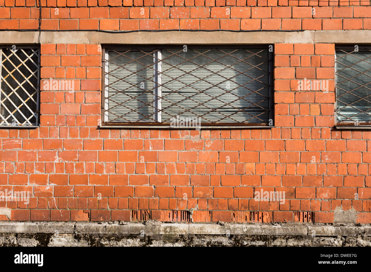 Red brick wall with metal window bars Stock Photo Alamy