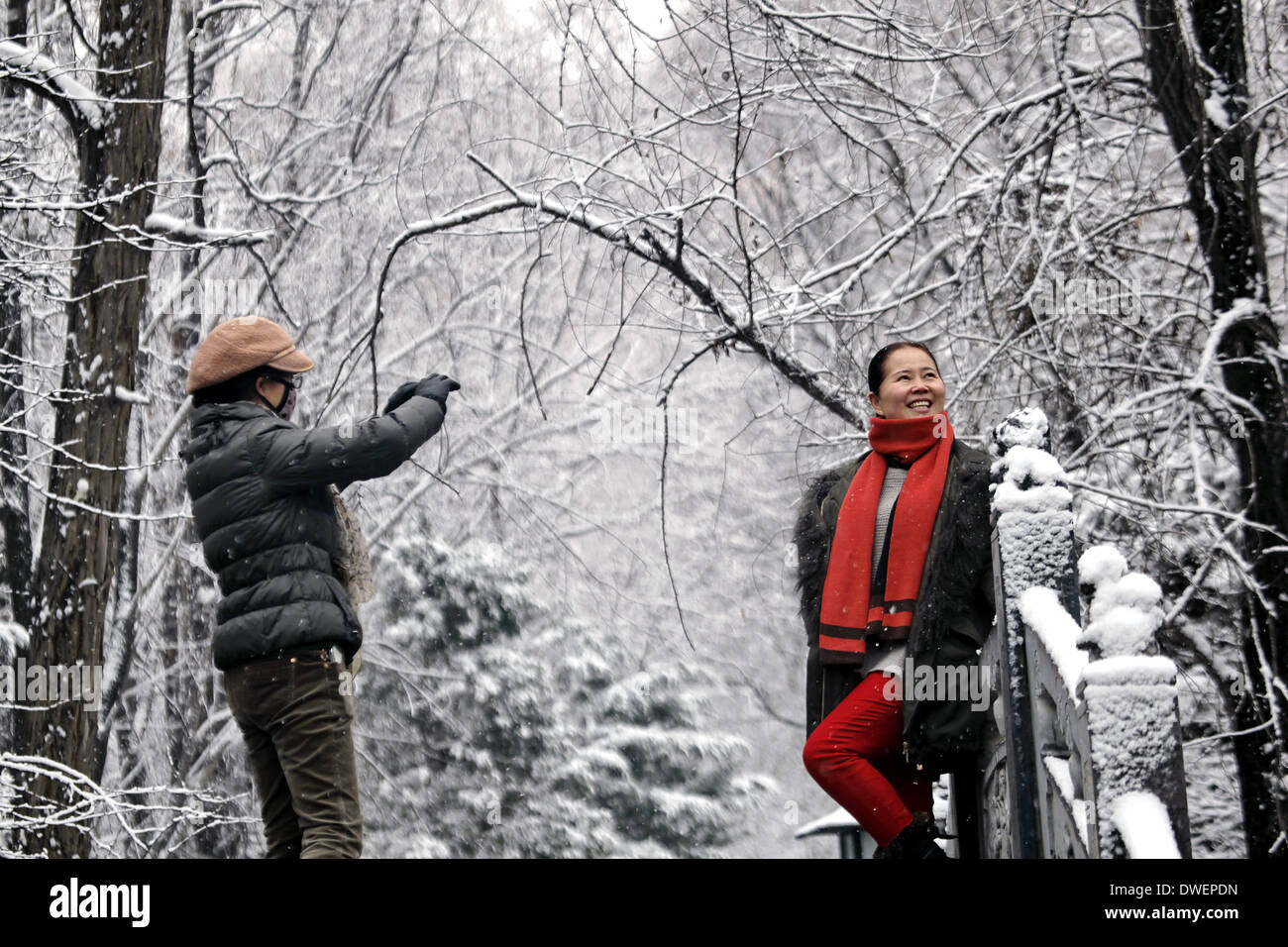 Pingliang, China's Gansu Province. 7th Mar, 2014. A tourist poses for photos in snow at a park in Pingliang City, northwest China's Gansu Province, March 7, 2014. Credit:  Yang Xin/Xinhua/Alamy Live News Stock Photo
