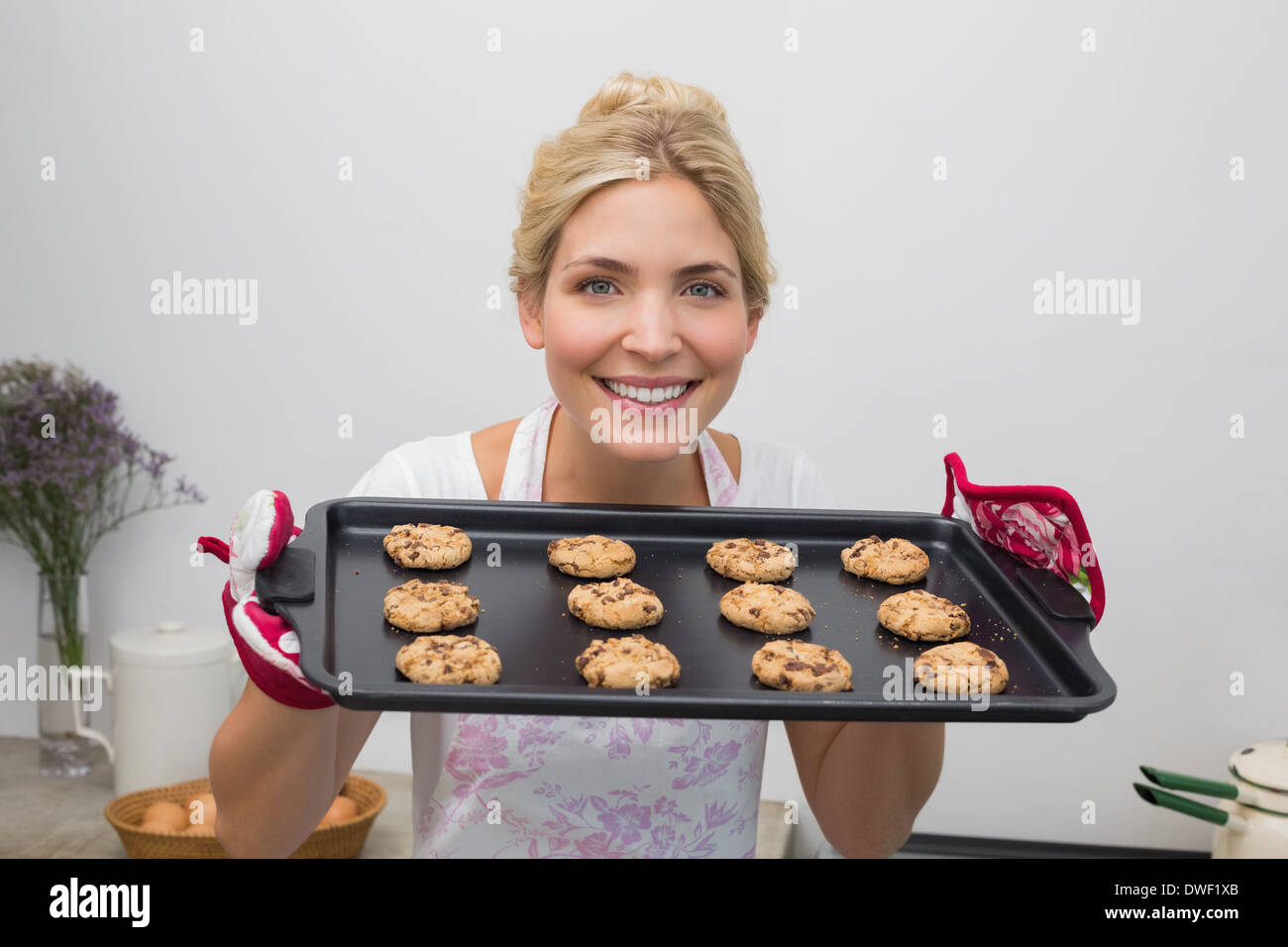 Smiling woman with a tray of cookies in the kitchen Stock Photo - Alamy