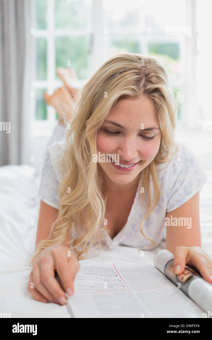 Beautiful young woman reading magazine in bed Stock Photo Alamy