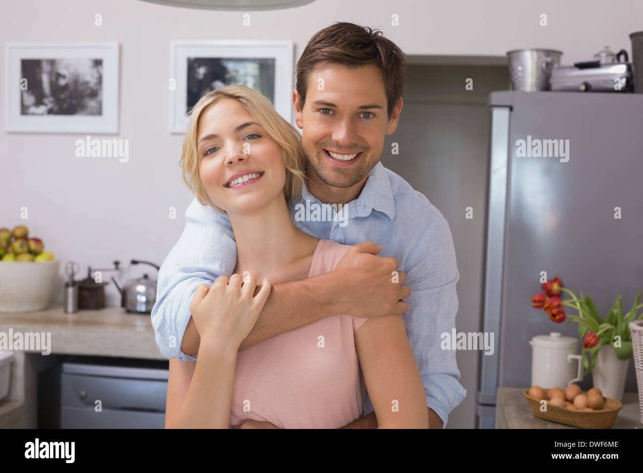 Man embracing woman from behind in kitchen Stock Photo - Alamy