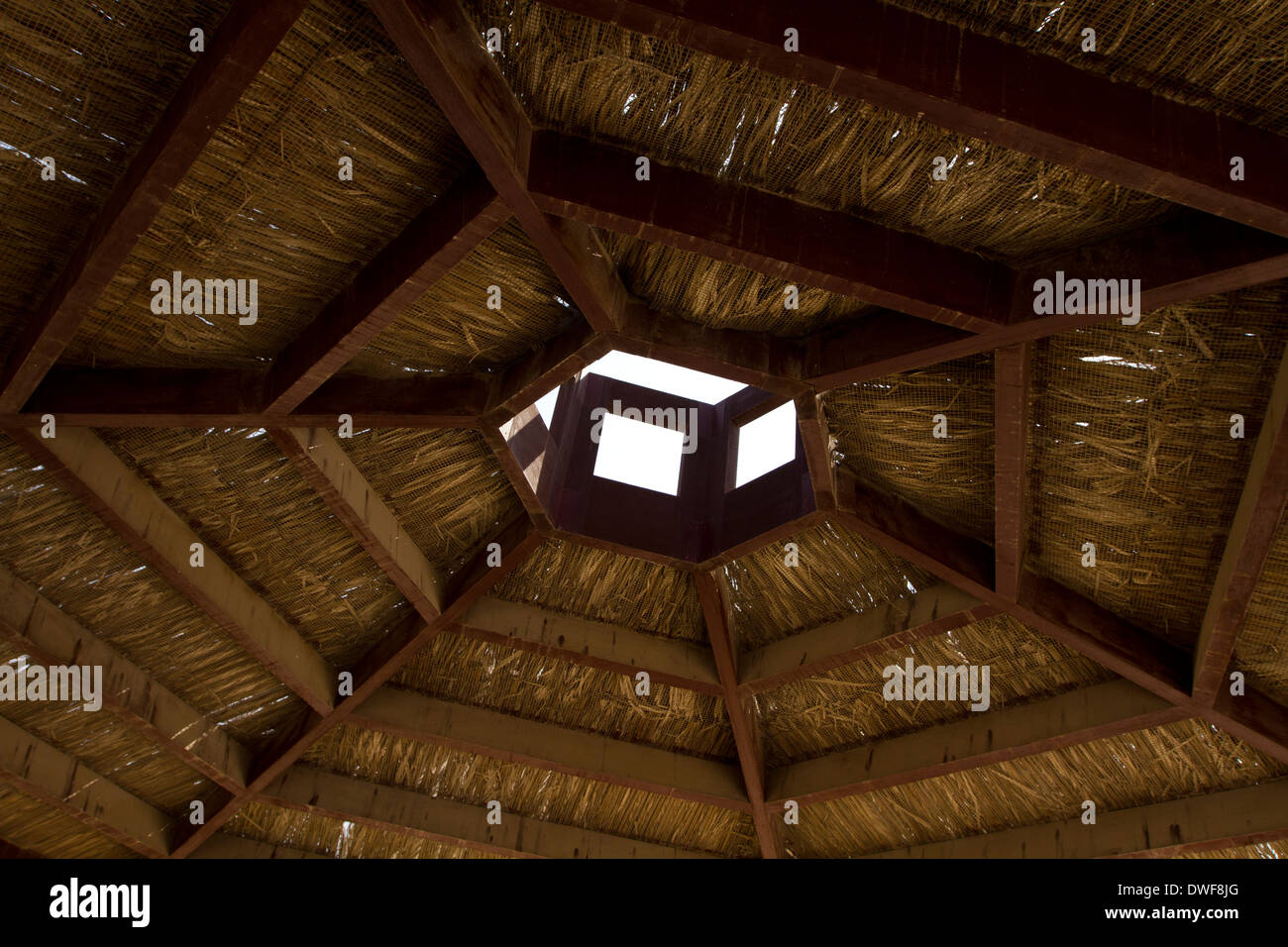 Traditional hexagonal wooden and Reed roof with hole Stock Photo