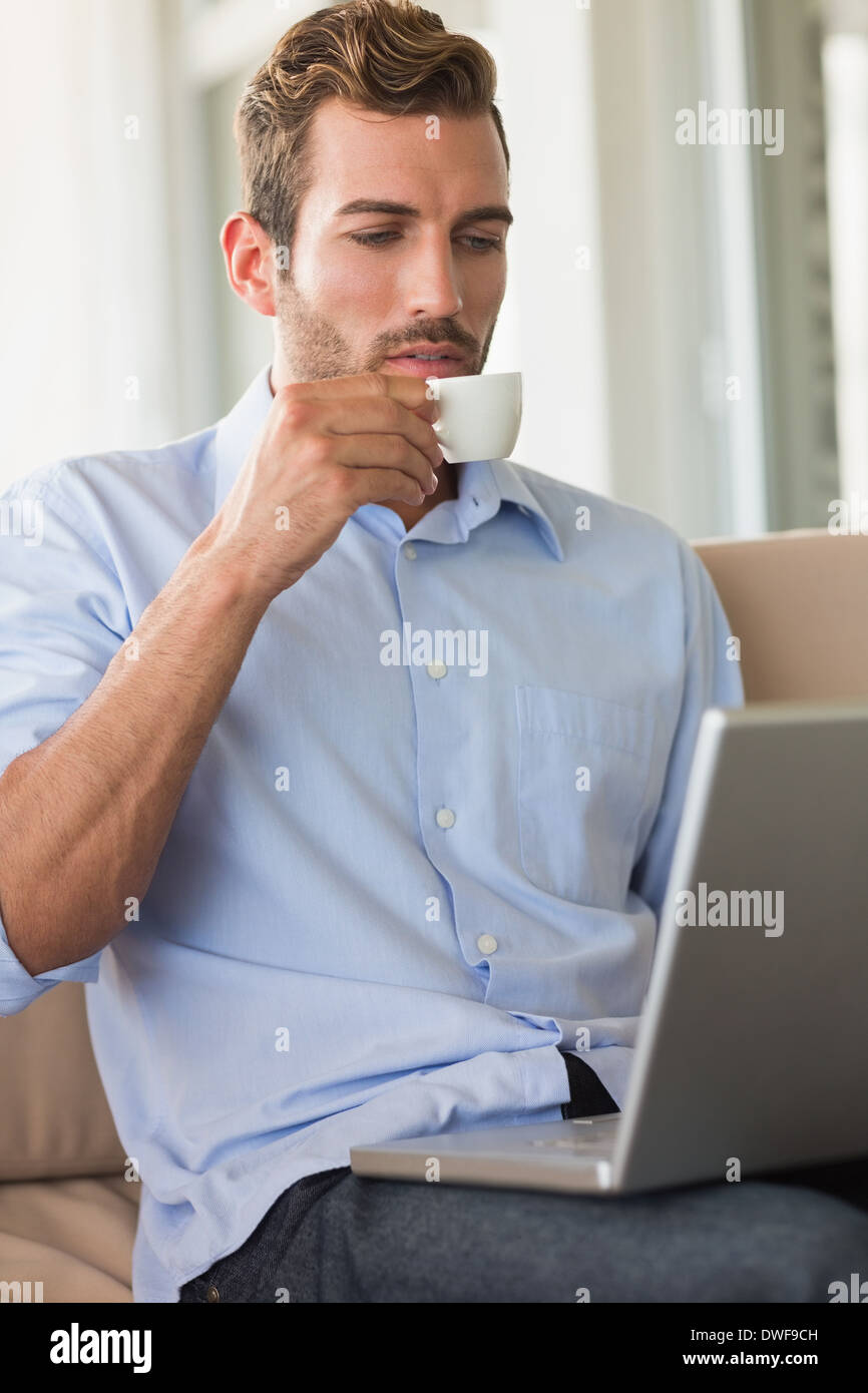 Handsome businessman working on laptop drinking espresso Stock Photo