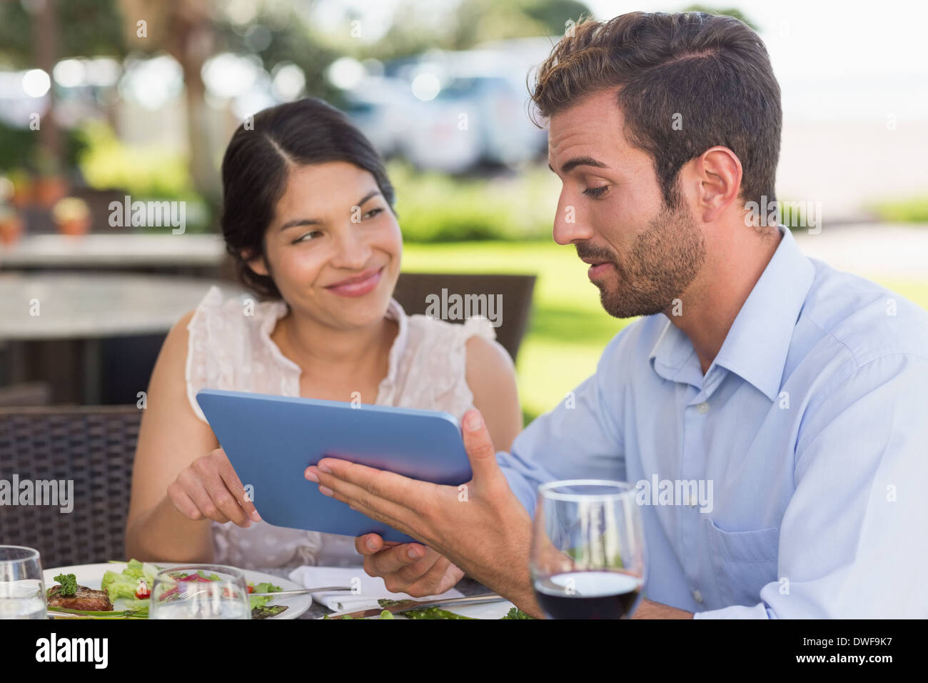 Happy couple on a date using tablet pc Stock Photo
