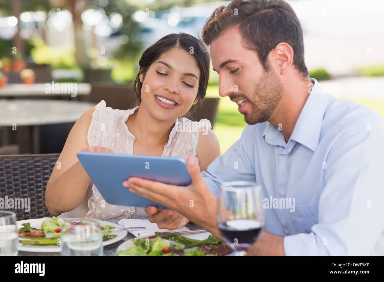 Happy couple on a date using tablet pc Stock Photo