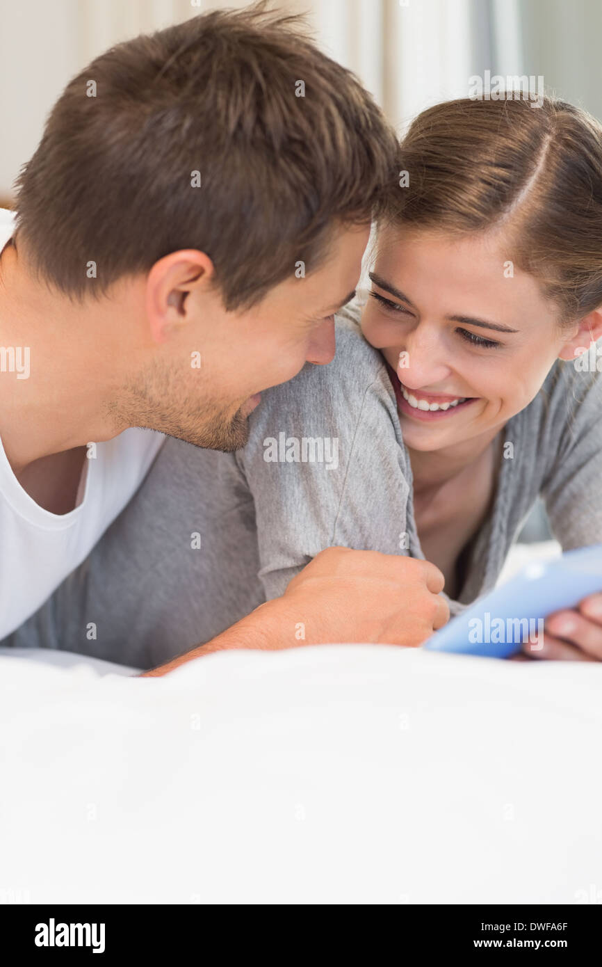 Happy couple on bed using tablet pc Stock Photo