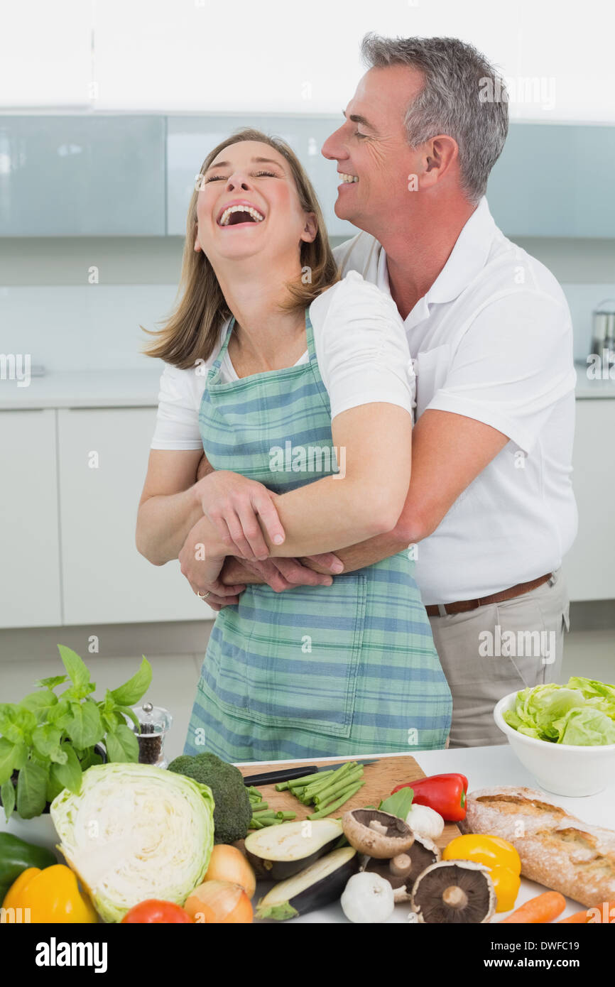 Side view of a man embracing woman in kitchen Stock Photo - Alamy