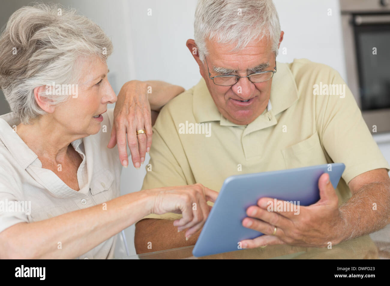 Happy senior couple using tablet pc at the table Stock Photo