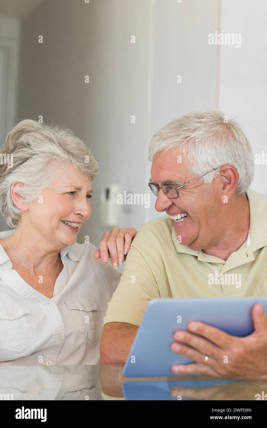 Happy senior couple using tablet pc at the table Stock Photo
