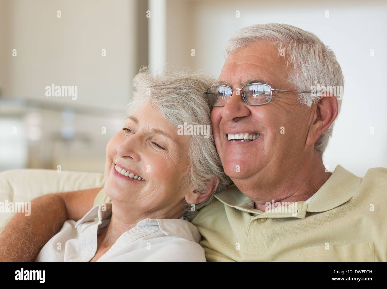Senior couple sitting on couch relaxing together Stock Photo
