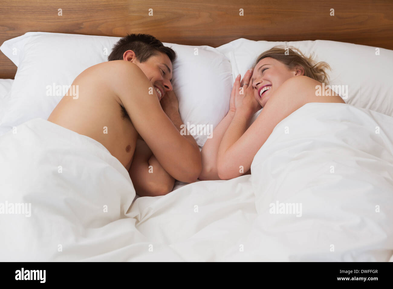 Happy relaxed young couple in bed Stock Photo