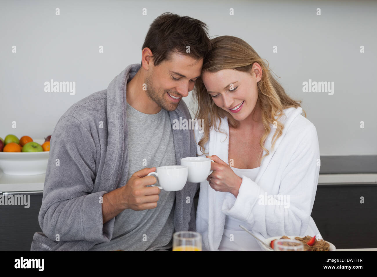 Young couple with coffee cups in kitchen Stock Photo