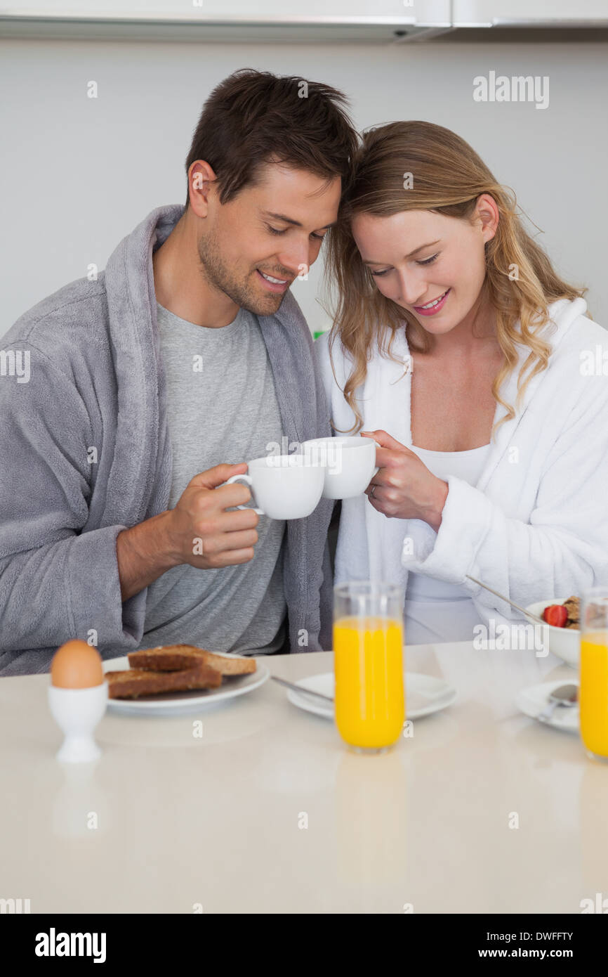 Young couple with coffee cups in kitchen Stock Photo