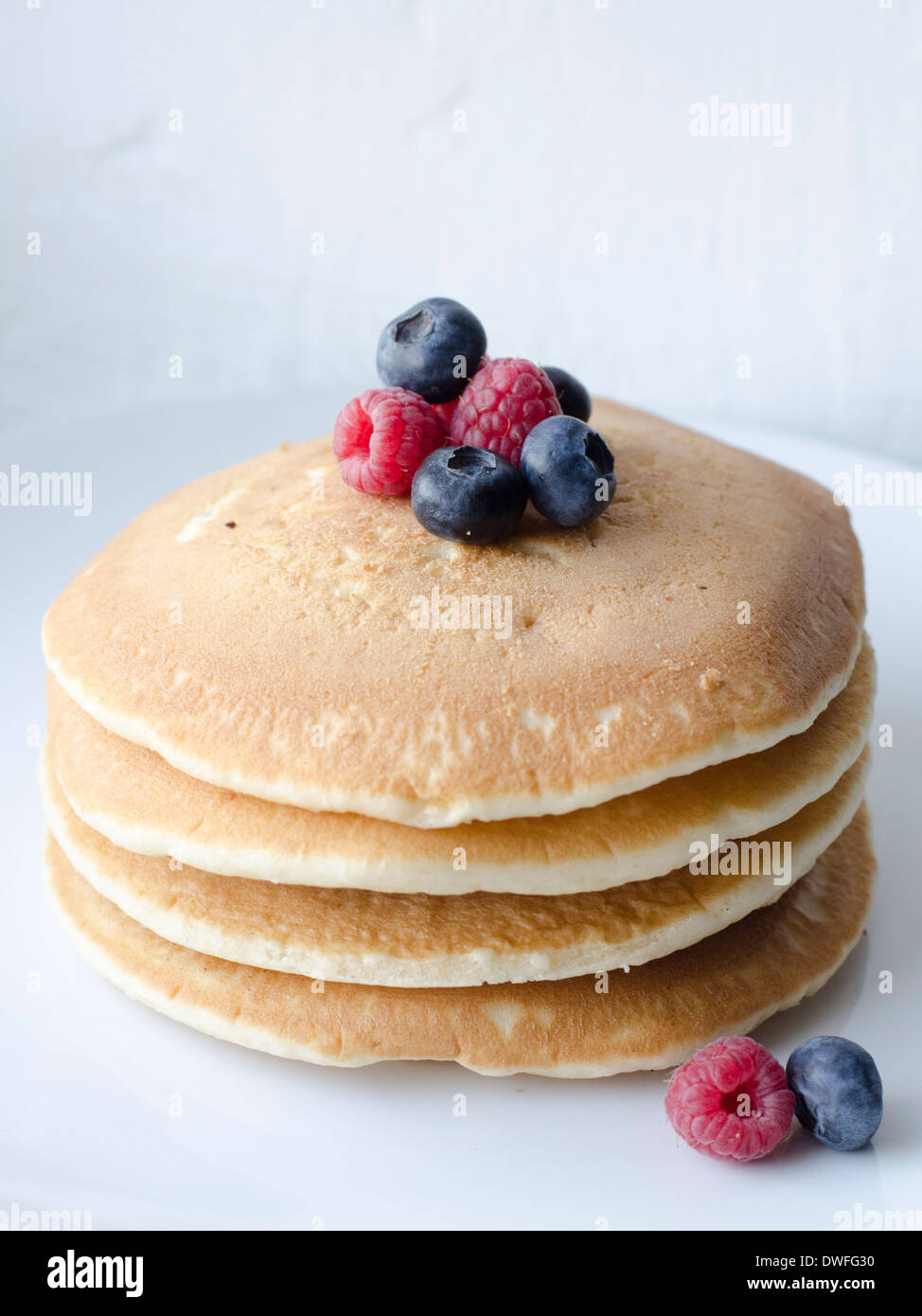 Amercian style pankcakes with raspberries and blueberries on top. Stock Photo