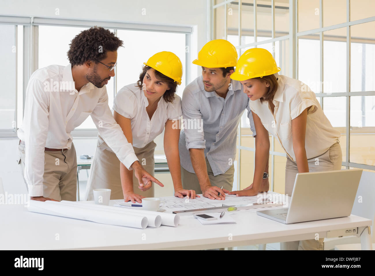 Colleagues working on blueprints at office Stock Photo