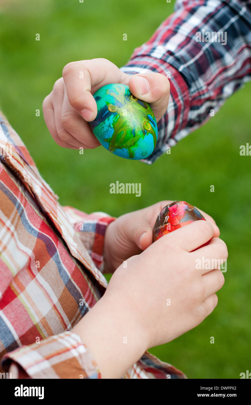 Two children hands hold Easter eggs Stock Photo