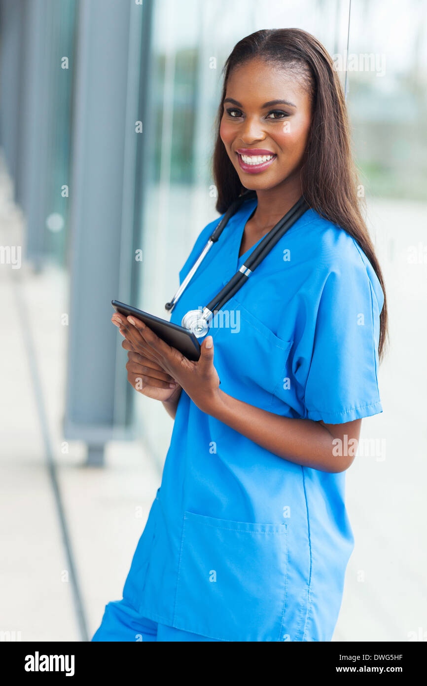 beautiful young African nurse holding tablet computer in office Stock Photo