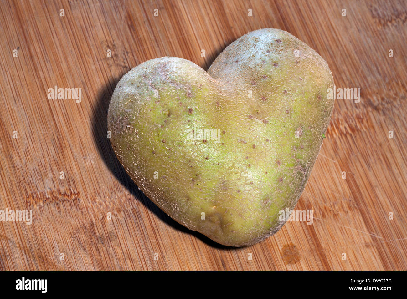 Heart-shaped potato on table Stock Photo
