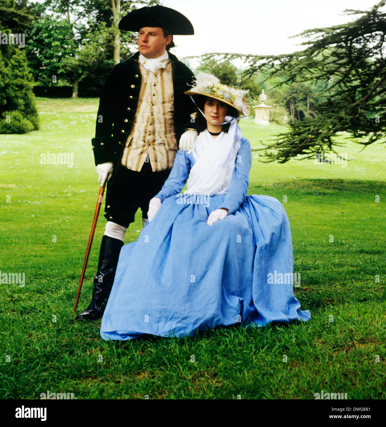 18th Century English Gentry in landscaped parkland, Audley End House gardens, Essex England UK, historical re-enactment costume costumes fashion fashions gentleman and lady Stock Photo