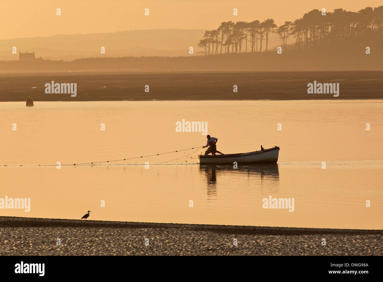 A fisherman hauling in his nets on the coast near Caernarfon in Gwynedd in Wales. Stock Photo