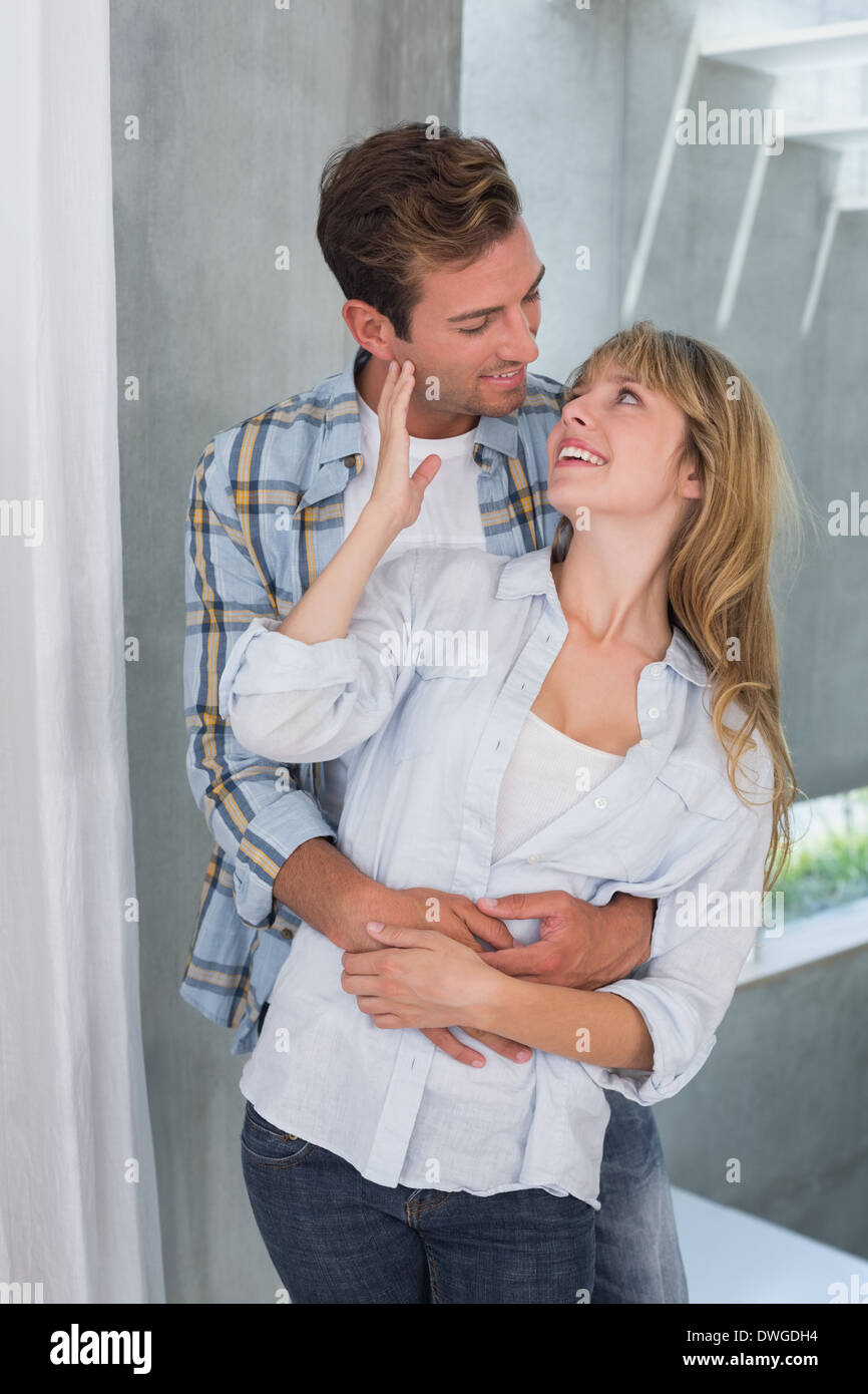 Loving young man embracing woman from behind Stock Photo - Alamy