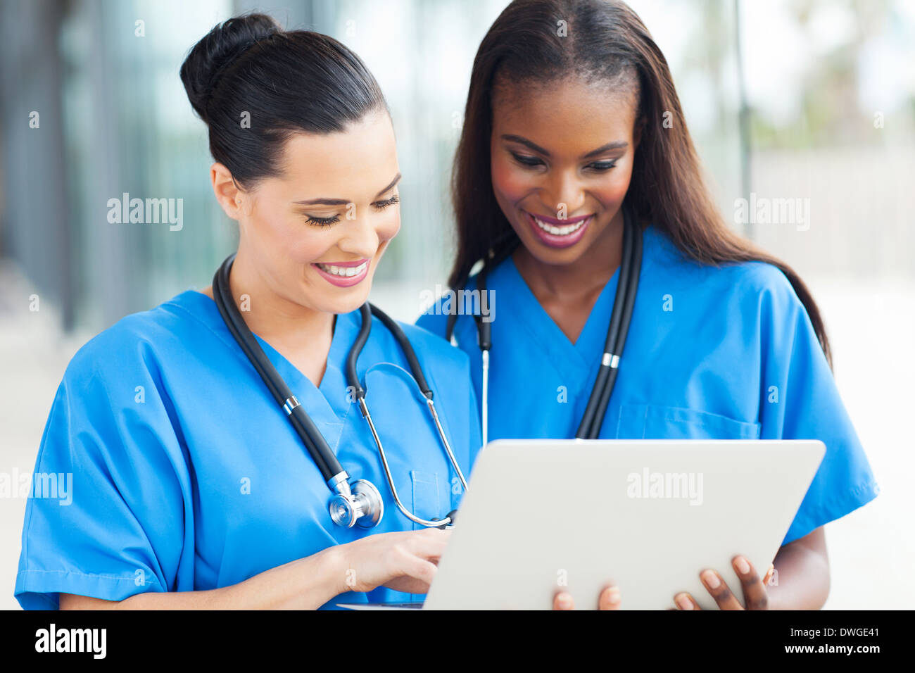 two cheerful female medical workers using laptop computer at hospital Stock Photo