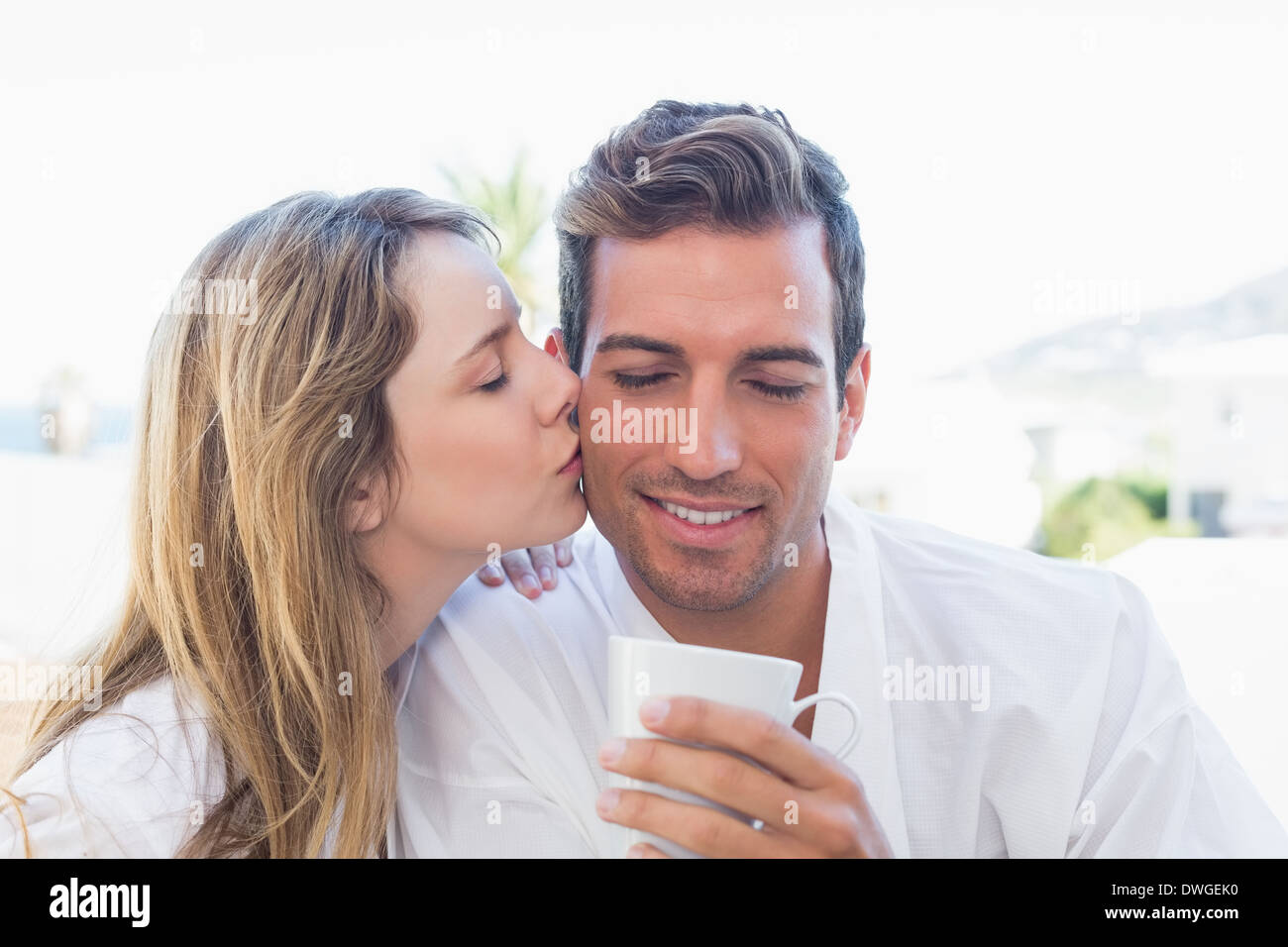 Woman kissing man while having coffee Stock Photo - Alamy