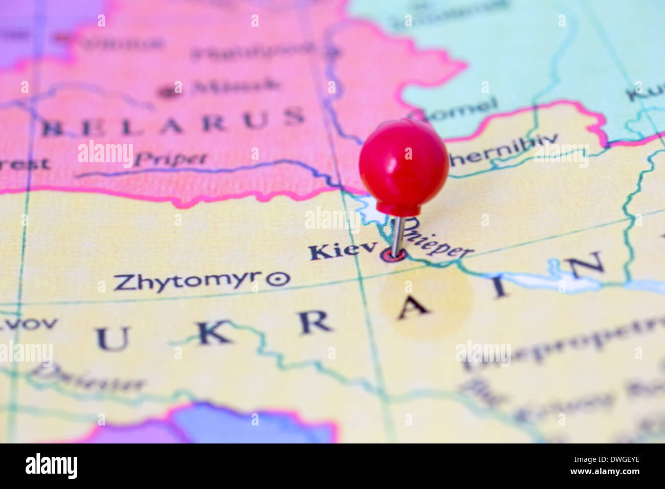 Round red thumb tack pinched through city of Kiev on Ukraine map. Part of collection covering all major capitals of Europe. Stock Photo